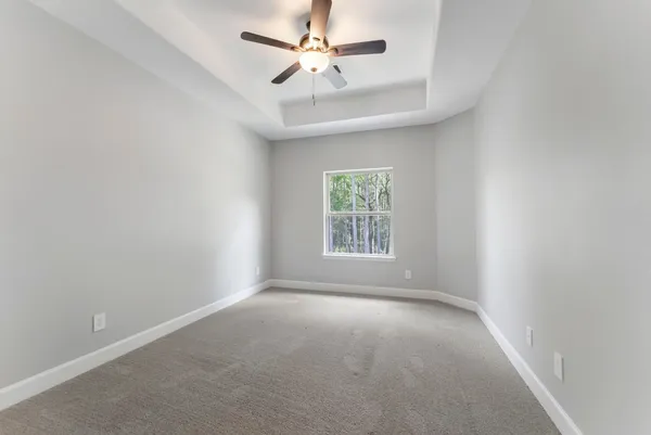 an empty room with a window and a fan