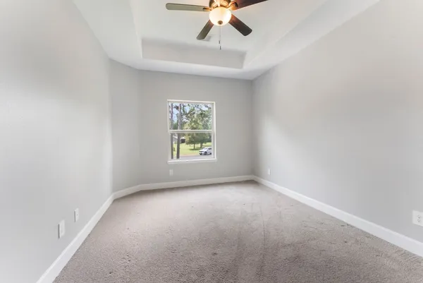 an empty room with a window and a fan