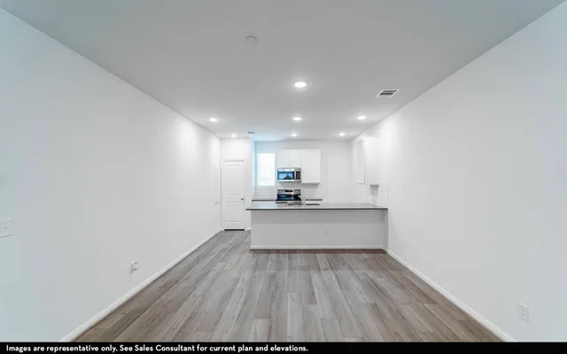 a view of a kitchen with kitchen island a sink wooden floor and floors