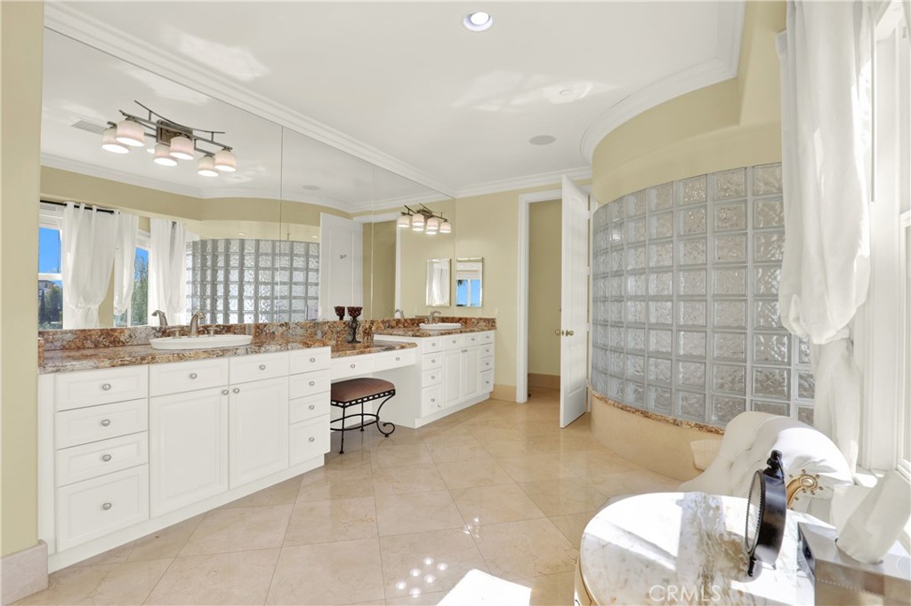 7231 Brandon Court Riverside, CA 92506 - Photo 39 of 69 a large bathroom with a granite countertop tub a double vanity sink a mirror and a shower