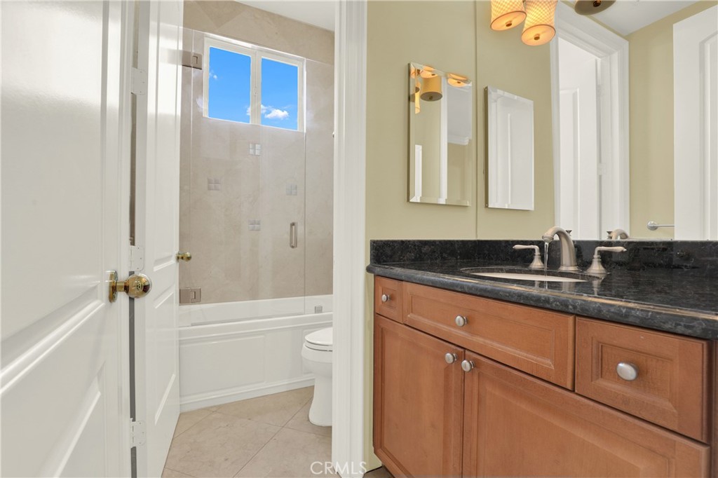 7231 Brandon Court Riverside, CA 92506 - Photo 46 of 69 a bathroom with a granite countertop sink a toilet and shower