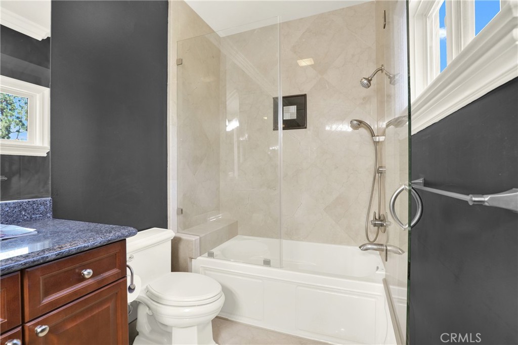 7231 Brandon Court Riverside, CA 92506 - Photo 49 of 69 a bathroom with a granite countertop sink a toilet and shower