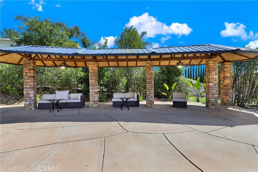 7231 Brandon Court Riverside, CA 92506 - Photo 61 of 69 a view of a patio with a table and chairs under an umbrella with a fire pit