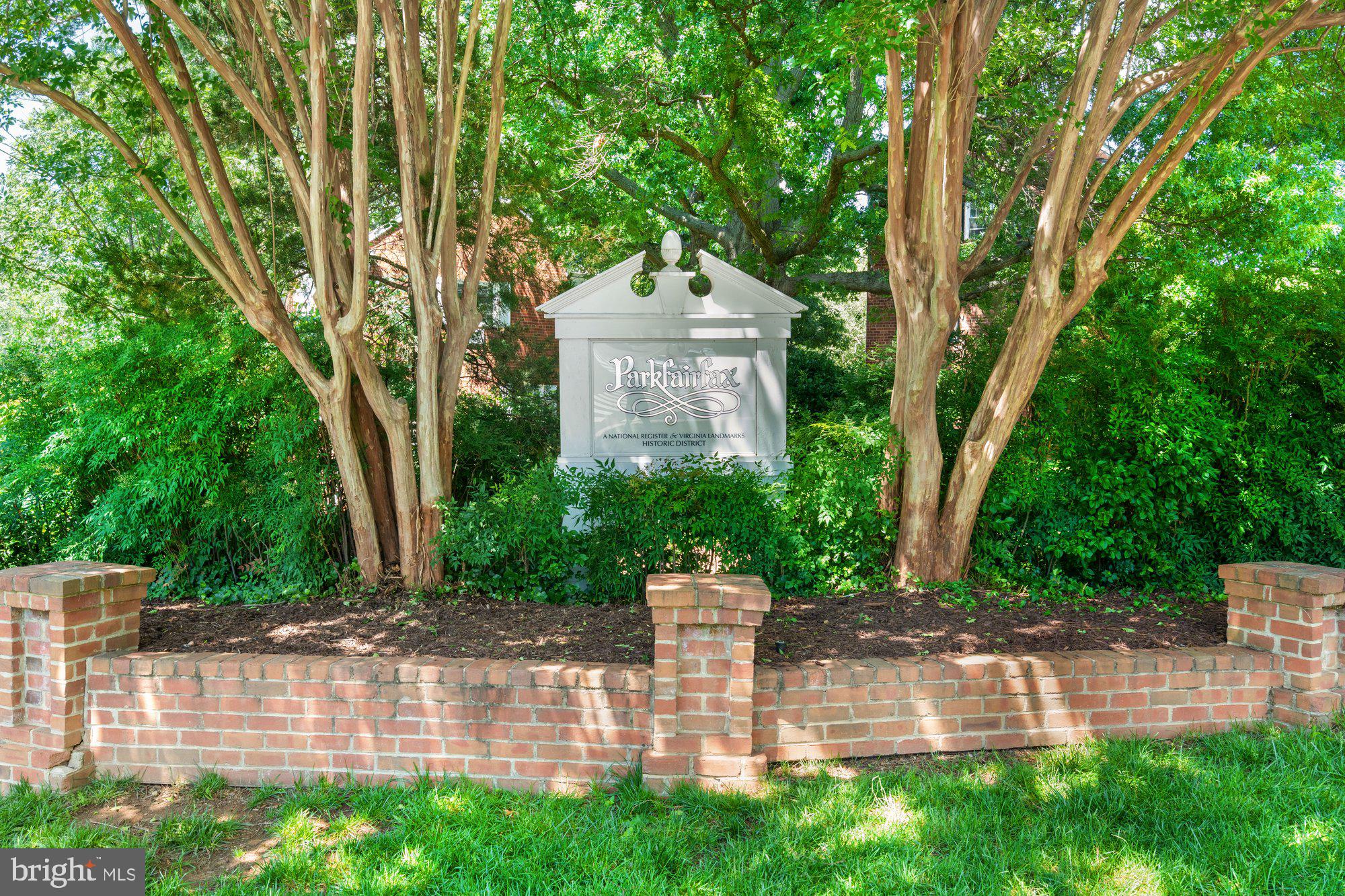 3304 Gunston Road Alexandria, VA 22302 - Photo 19 of 28 a view of a brick house with a small yard and large trees