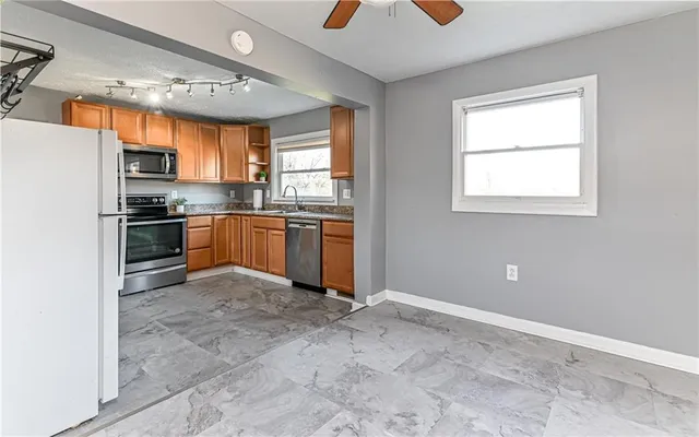 a kitchen with stainless steel appliances granite countertop a stove a sink and a refrigerator