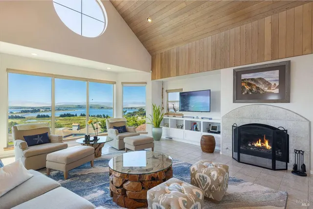 a living room with fireplace furniture and floor to ceiling windows