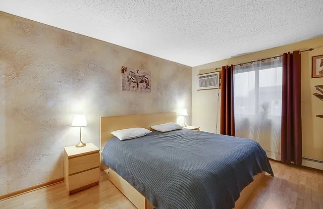 a bedroom with a bed and painting on the wall