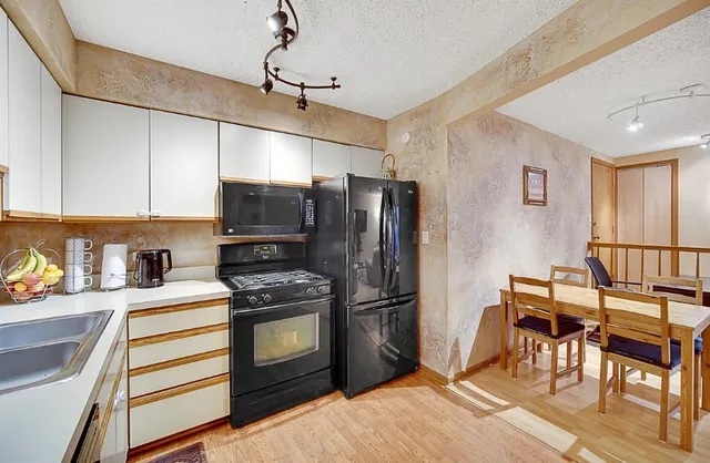 a kitchen with granite countertop a refrigerator stove and microwave