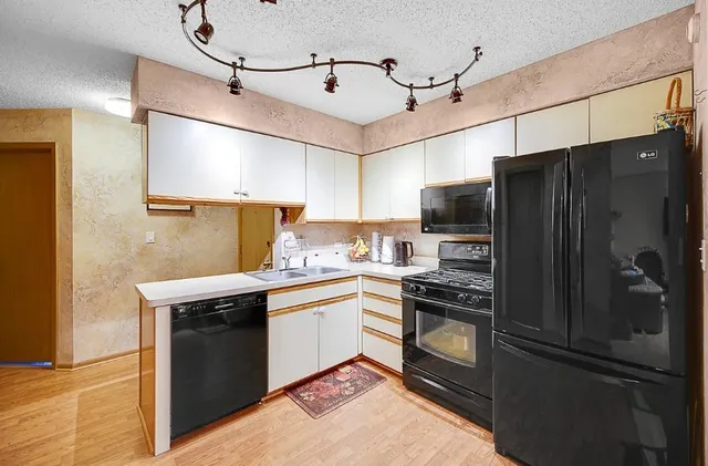 a kitchen with stainless steel appliances granite countertop a refrigerator and a sink