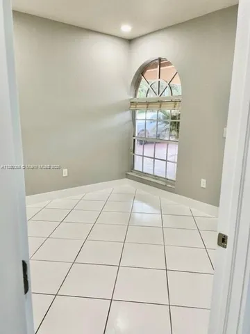 an empty room with window and mirror