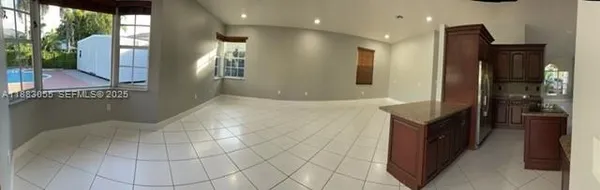 a kitchen with stainless steel appliances kitchen island granite countertop a refrigerator and a sink