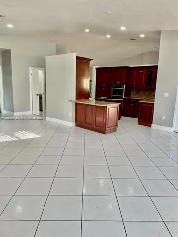 a large kitchen with stainless steel appliances a large counter top and cabinets