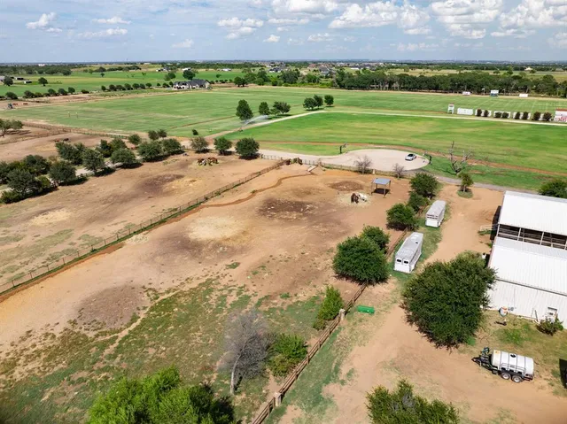 an aerial view of a golf course with a building in the background