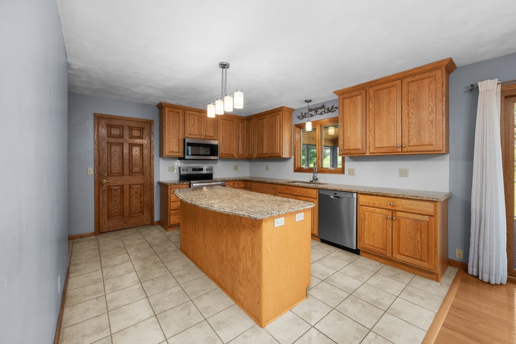 207 Amber Lane Geneseo, IL 61254 - Photo 12 of 57 a kitchen with stainless steel appliances granite countertop a stove a sink dishwasher and a refrigerator