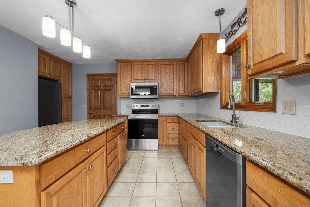 207 Amber Lane Geneseo, IL 61254 - Photo 14 of 57 a kitchen with stainless steel appliances granite countertop a sink counter space cabinets and a large window