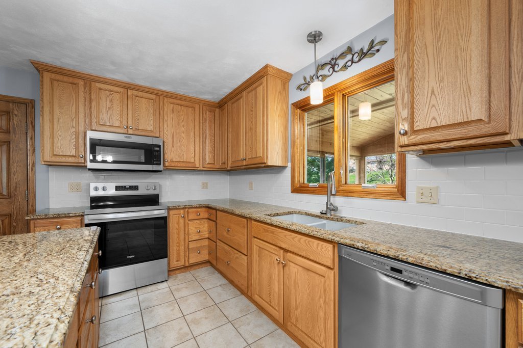 207 Amber Lane Geneseo, IL 61254 - Photo 16 of 57 a kitchen with stainless steel appliances granite countertop a stove a sink and a microwave