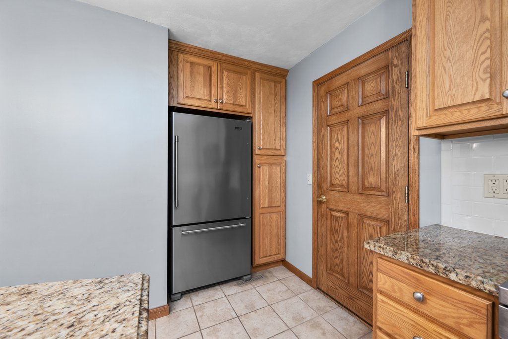 207 Amber Lane Geneseo, IL 61254 - Photo 17 of 57 a kitchen with granite countertop a refrigerator and cabinets