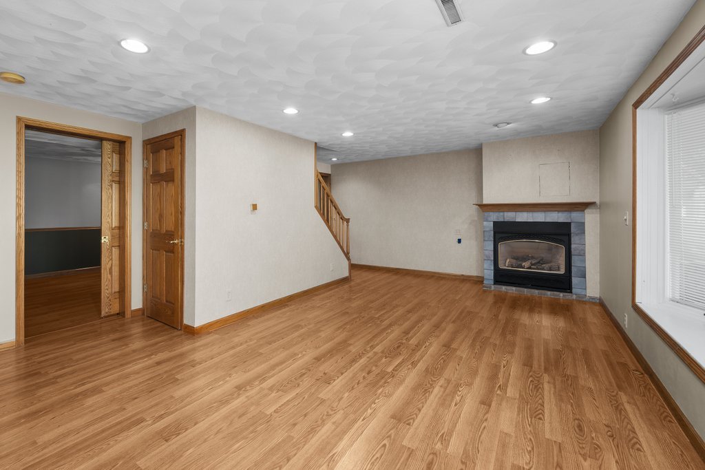 207 Amber Lane Geneseo, IL 61254 - Photo 32 of 57 a view of empty room with wooden floor and fireplace