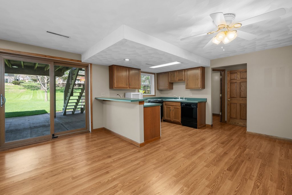 207 Amber Lane Geneseo, IL 61254 - Photo 34 of 57 a open kitchen with kitchen island a stove a refrigerator cabinets and wooden floor