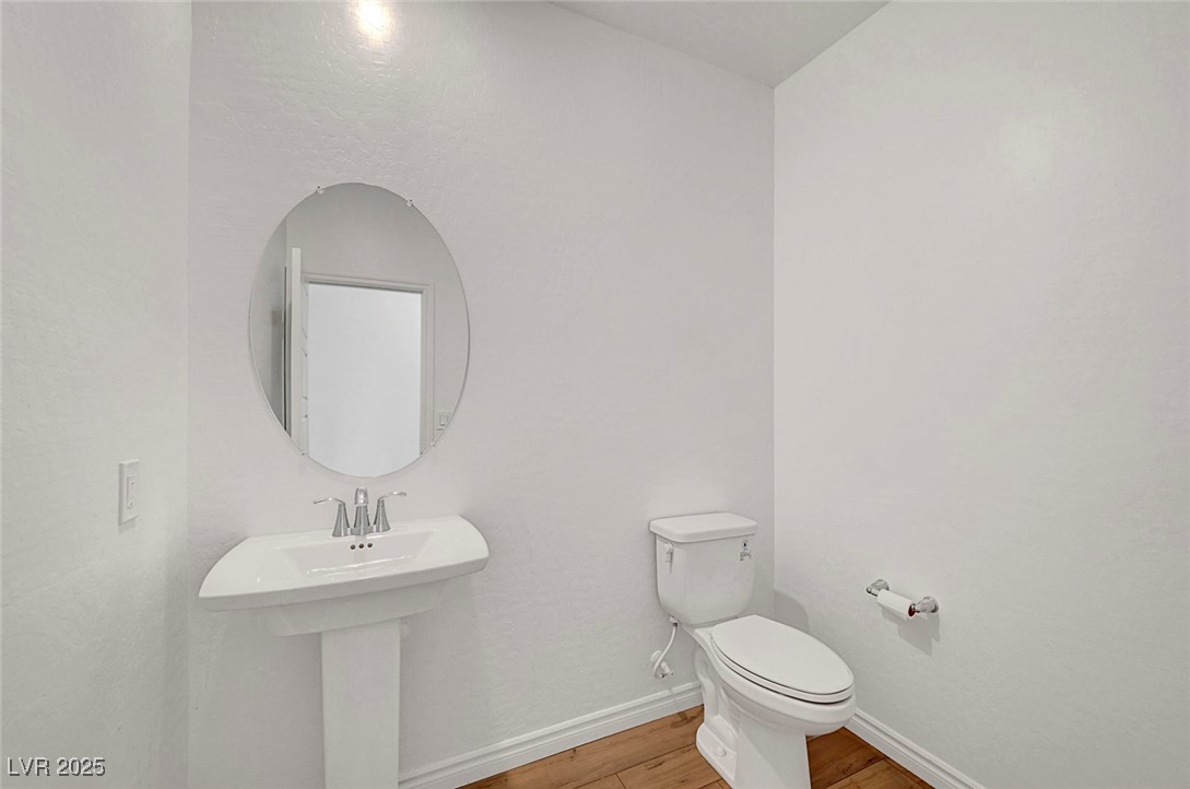 7204 North Decatur Boulevard North Las Vegas, NV 89084 - Photo 28 of 55 Bathroom featuring baseboards, wood finished floors, toilet, and a sink