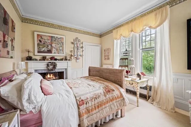 a living room with furniture lots of books and a large window