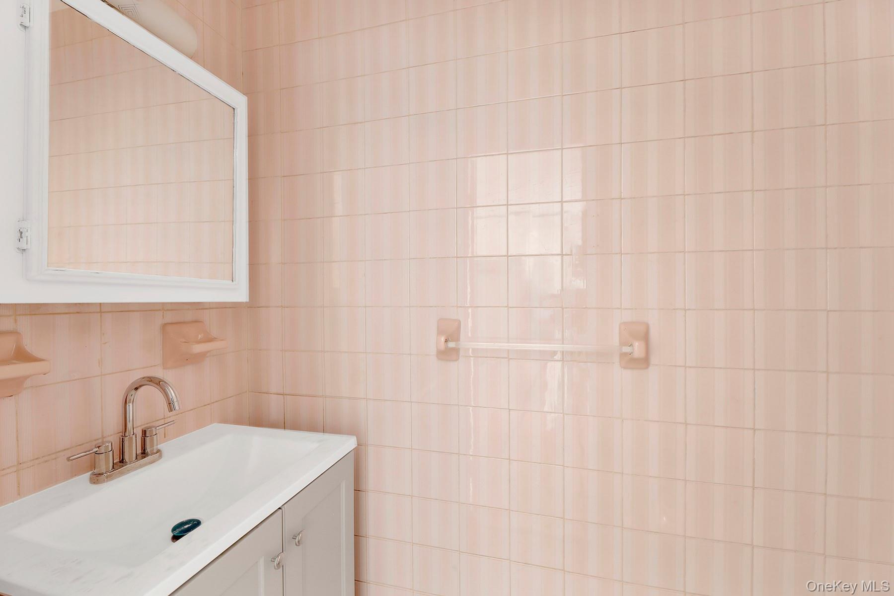 559 Cleveland Street Brooklyn, NY 11208 - Photo 12 of 34 Half bath with vanity and tile walls