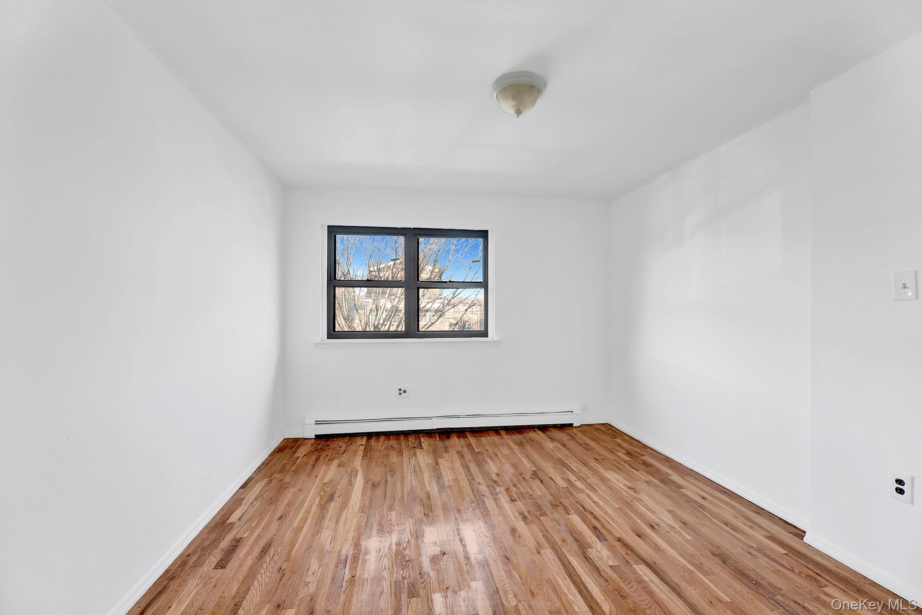 559 Cleveland Street Brooklyn, NY 11208 - Photo 25 of 34 Unfurnished room with light wood-style floors and baseboard heating