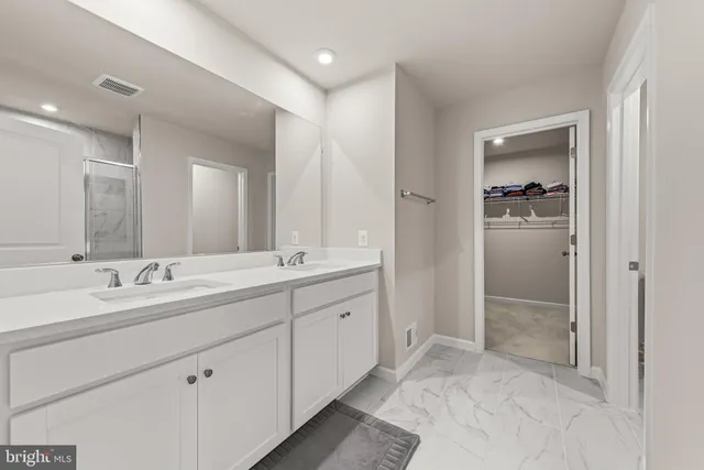 a spacious bathroom with a double vanity sink shower and a mirror