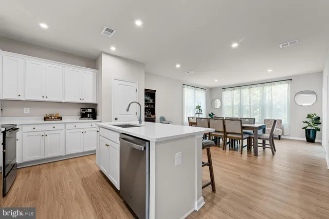 a kitchen that has a lot of cabinets in it with a dining table and chairs