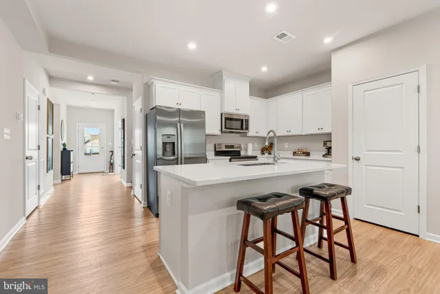 a kitchen with stainless steel appliances kitchen island granite countertop a refrigerator and a stove top oven