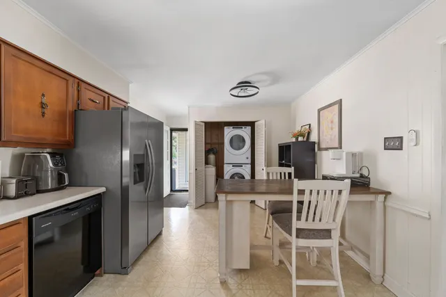 a kitchen with stainless steel appliances kitchen island granite countertop a refrigerator a stove a sink dishwasher and white cabinets with wooden floor