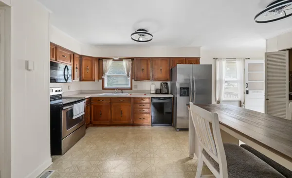 a kitchen with stainless steel appliances granite countertop a stove a sink dishwasher a refrigerator and a refrigerator
