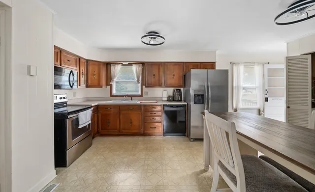 a kitchen with stainless steel appliances granite countertop a stove a sink dishwasher a refrigerator and a refrigerator