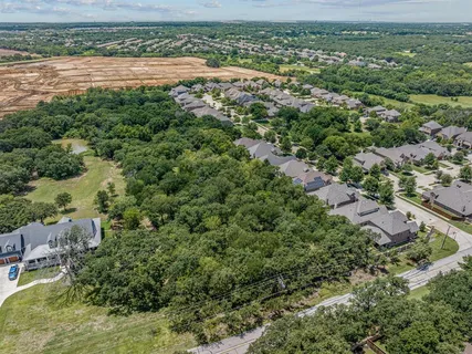 an aerial view of residential houses with outdoor space and trees