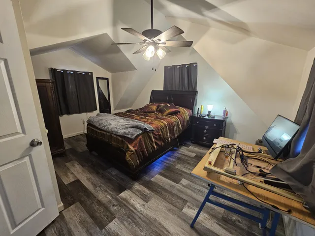 a bedroom with bed and wooden floor