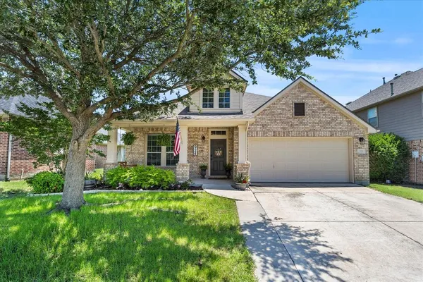 a front view of a house with a yard and potted plants
