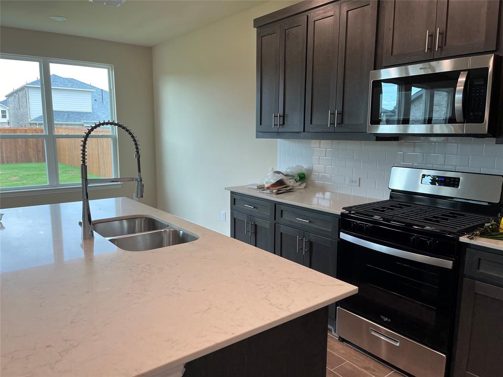 1013 Amendun Lane Anna, TX 75409 - Photo 6 of 19 a kitchen with a stove a sink and a microwave