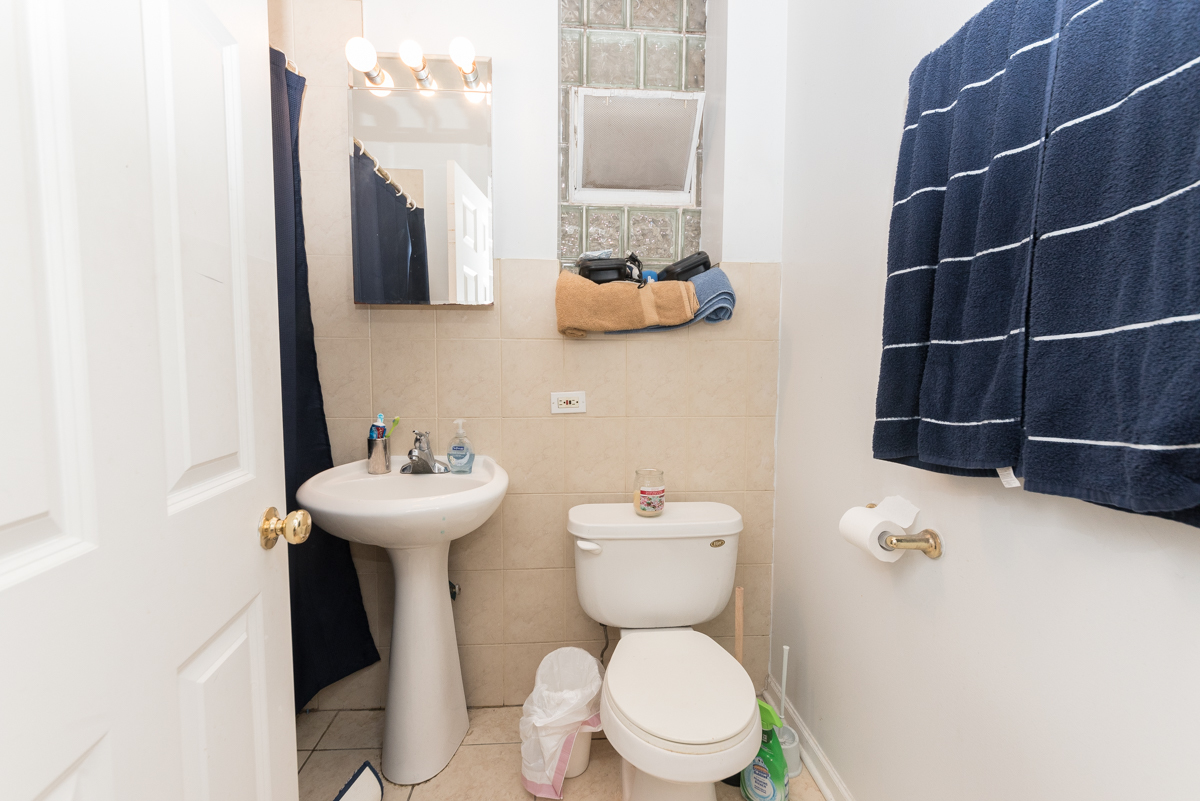 2139 West Huron Street, Unit 1F Chicago, IL 60612 - Photo 11 of 12 a bathroom with a sink a toilet and a mirror
