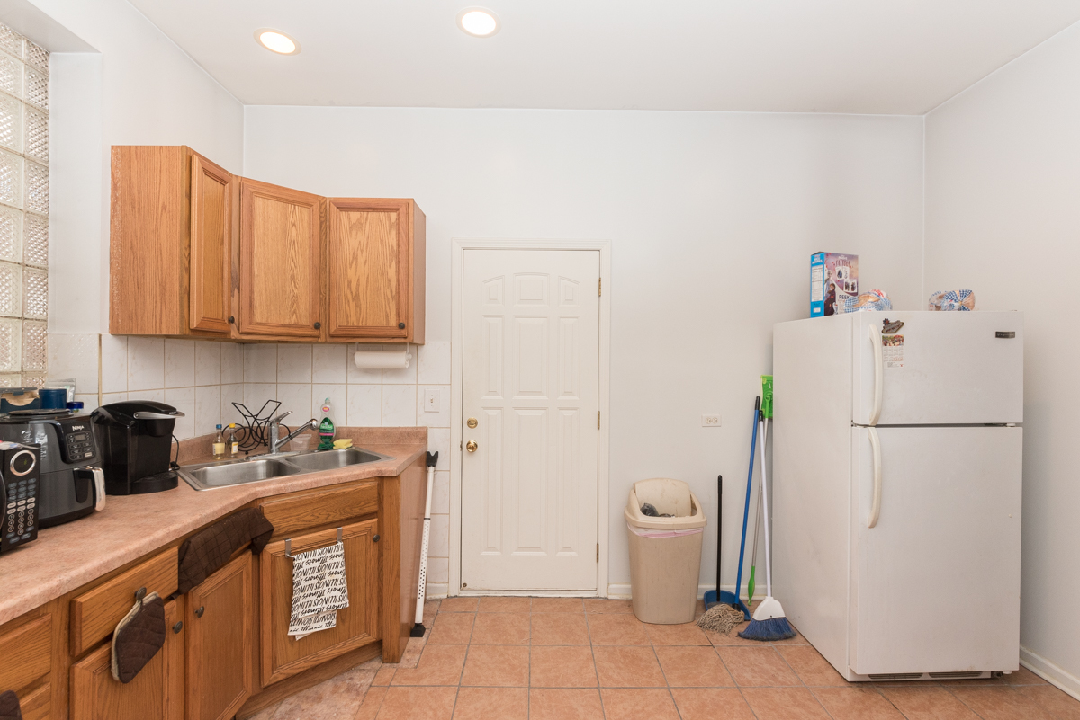 2139 West Huron Street, Unit 1F Chicago, IL 60612 - Photo 7 of 12 a kitchen with a refrigerator a stove top oven and a sink