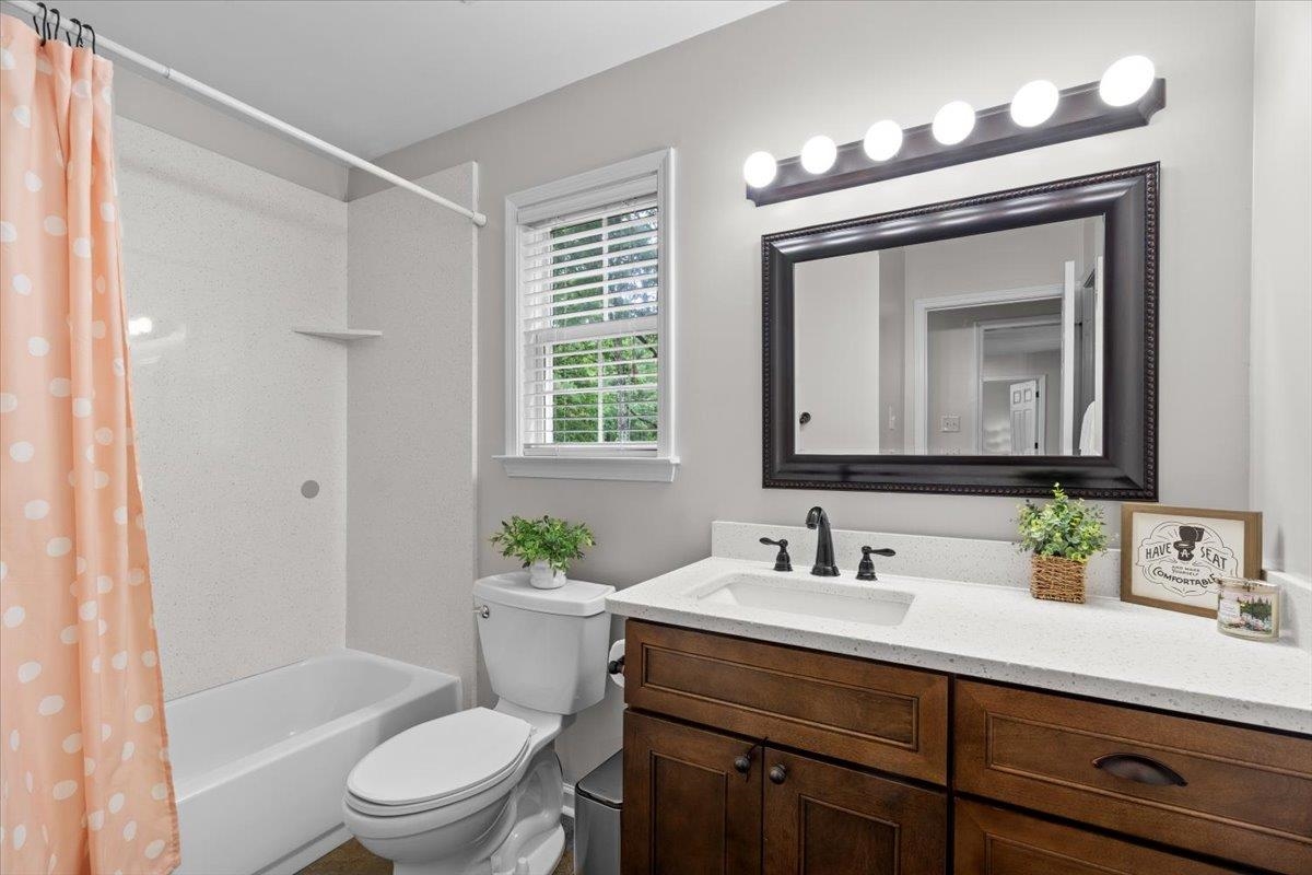 150 Liberty Road Moscow, TN 38057 - Photo 16 of 36 Bathroom featuring a vanity with dark wood cabinetry and a light-toned countertop, a rectangular undermount sink with a dark-finish faucet, and a framed mirror with a prominent vanity light fixture