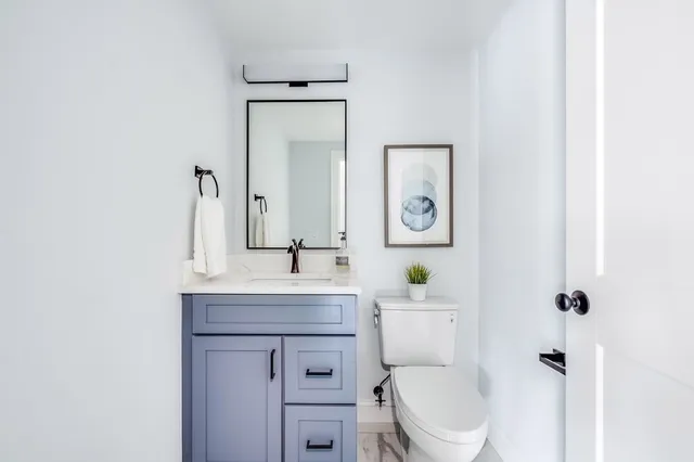 a bathroom with a toilet a sink and mirror