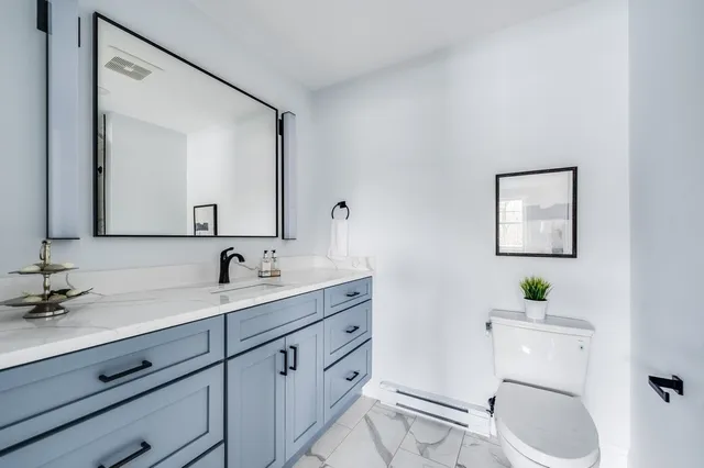 a bathroom with a toilet sink and mirror
