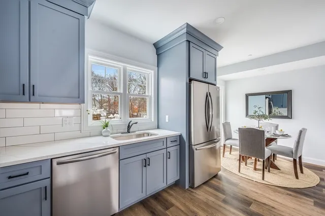 a kitchen with a refrigerator a sink and chairs