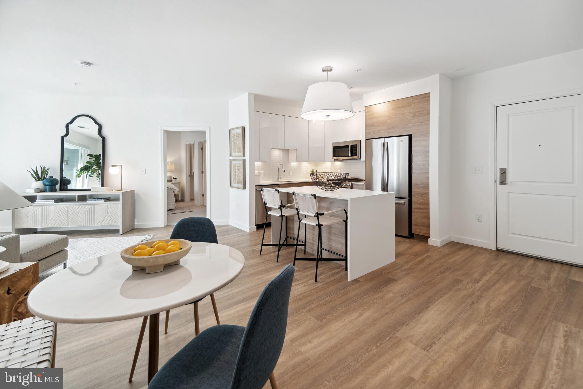 3820 Chaplin Place, Unit 1104/CLAUDE Chevy Chase, MD 20815 - Photo 7 of 26 a kitchen with stainless steel appliances granite countertop a dining table chairs and white cabinets