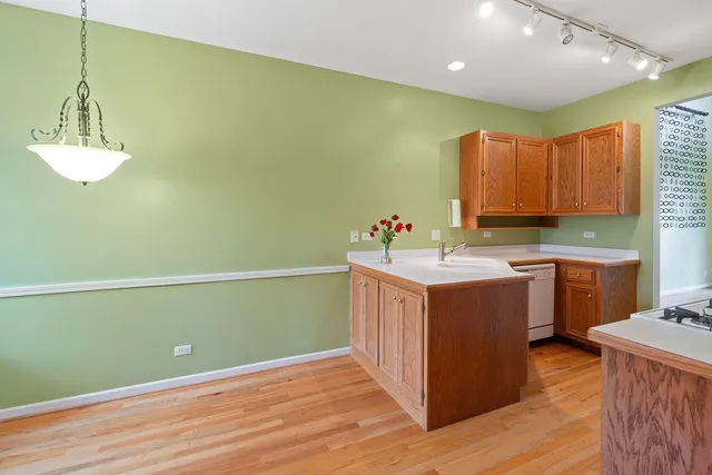 a kitchen with sink a refrigerator and wooden cabinets