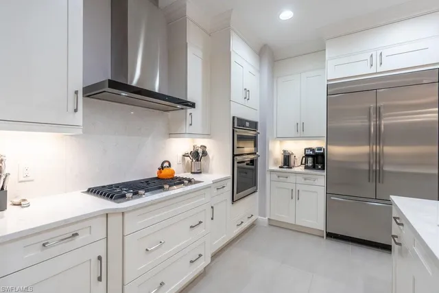 a kitchen with white cabinets and stainless steel appliances