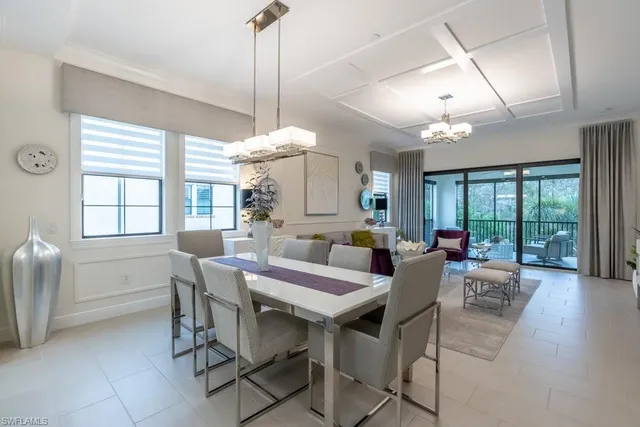 a view of a dining room and livingroom with furniture wooden floor a chandelier