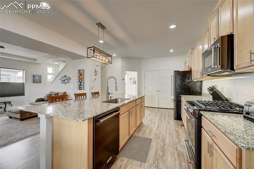 9642 Timberlake Loop Colorado Springs, CO 80927 - Photo 14 of 46 a kitchen with stainless steel appliances granite countertop a sink stove and refrigerator