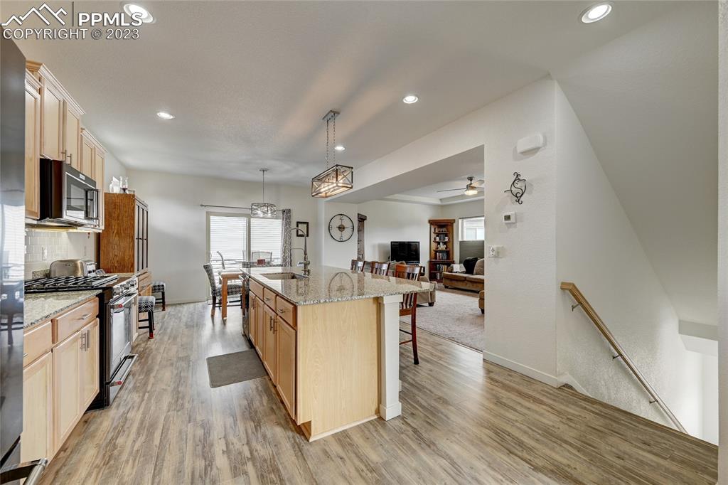 9642 Timberlake Loop Colorado Springs, CO 80927 - Photo 16 of 46 a kitchen with stainless steel appliances granite countertop wooden floors and sink