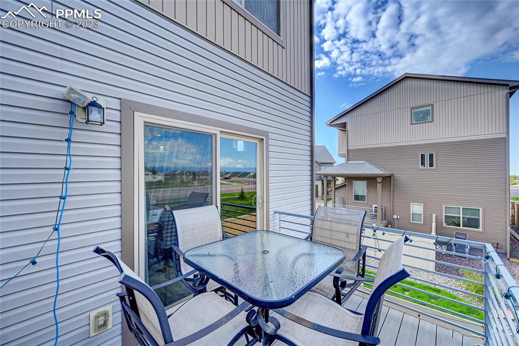 9642 Timberlake Loop Colorado Springs, CO 80927 - Photo 20 of 46 a view of a patio with a dining table and chairs with wooden floor